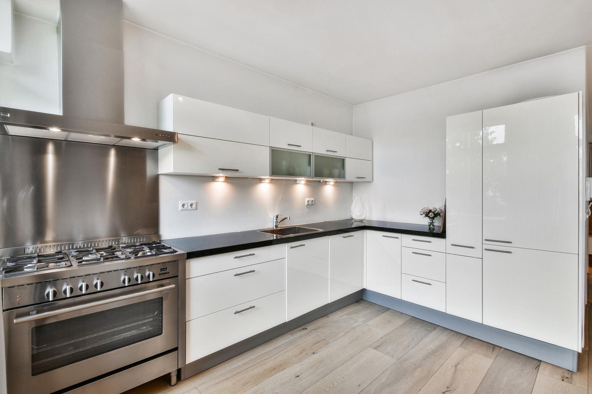 A kitchen with white cabinets and stainless steel appliances