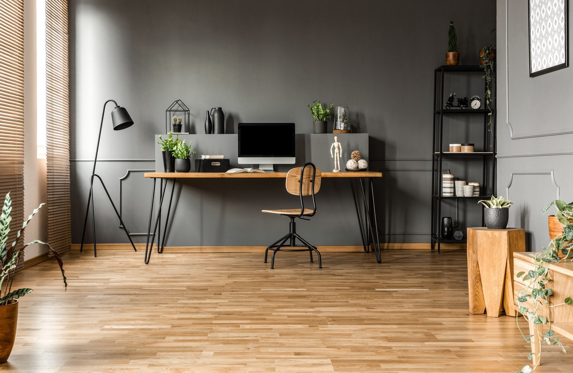 There is a desk with a computer on it in the middle of the room.