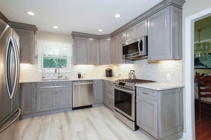 A man is installing cabinets in a kitchen.