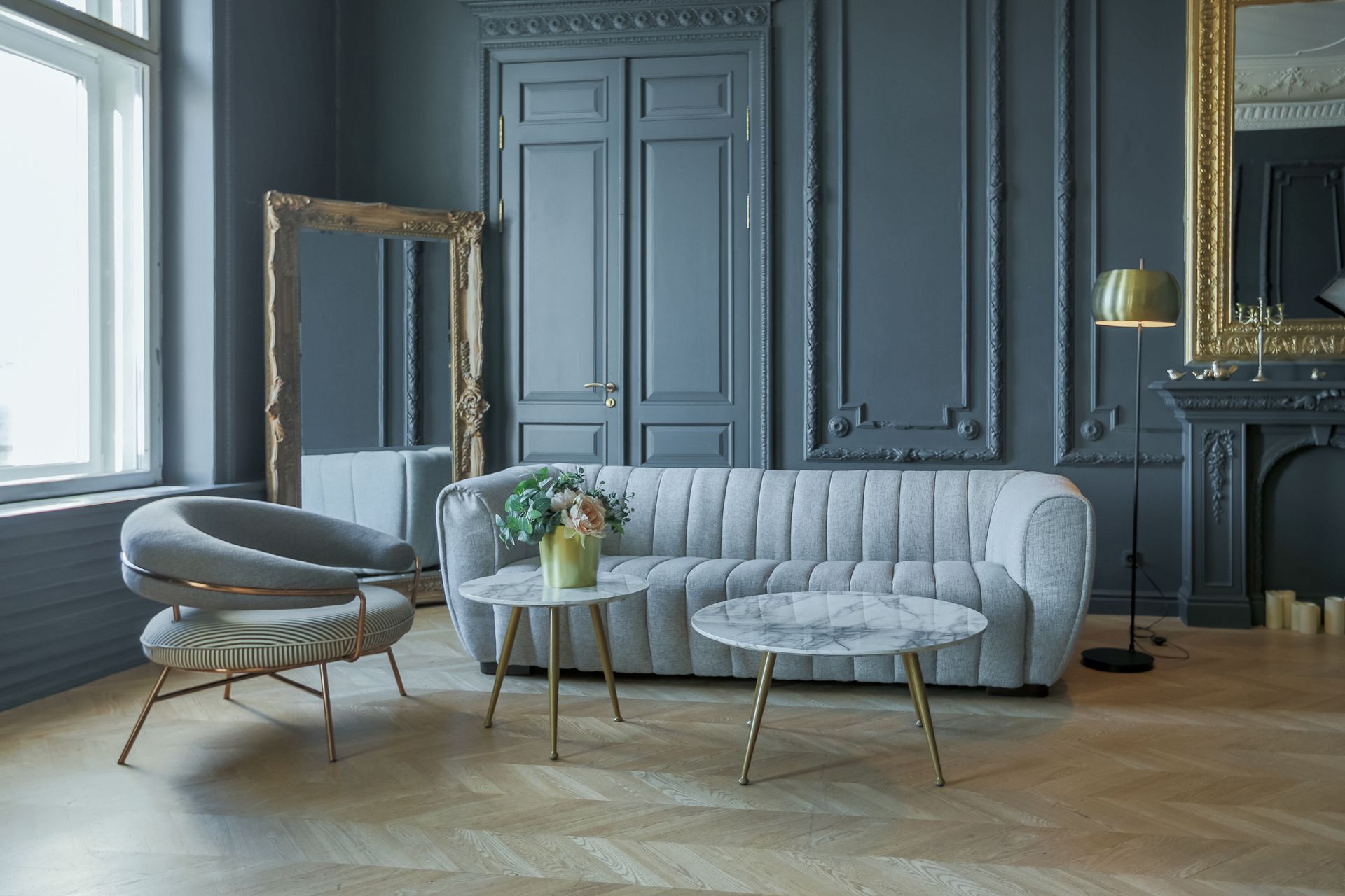 A living room with a couch , chair , table and mirror.