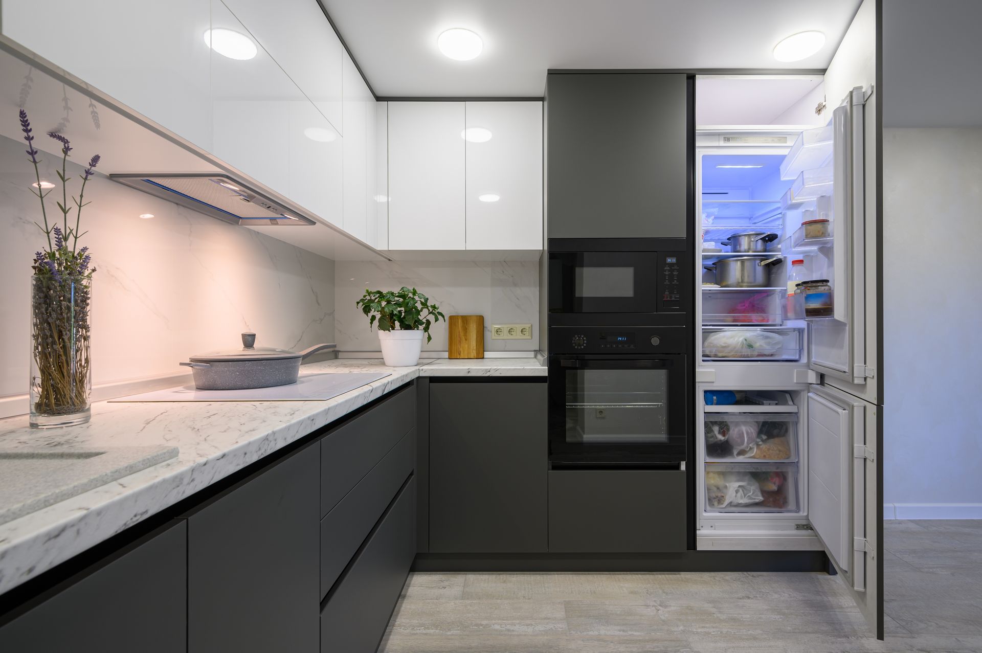 A kitchen with a refrigerator , oven , microwave and sink.