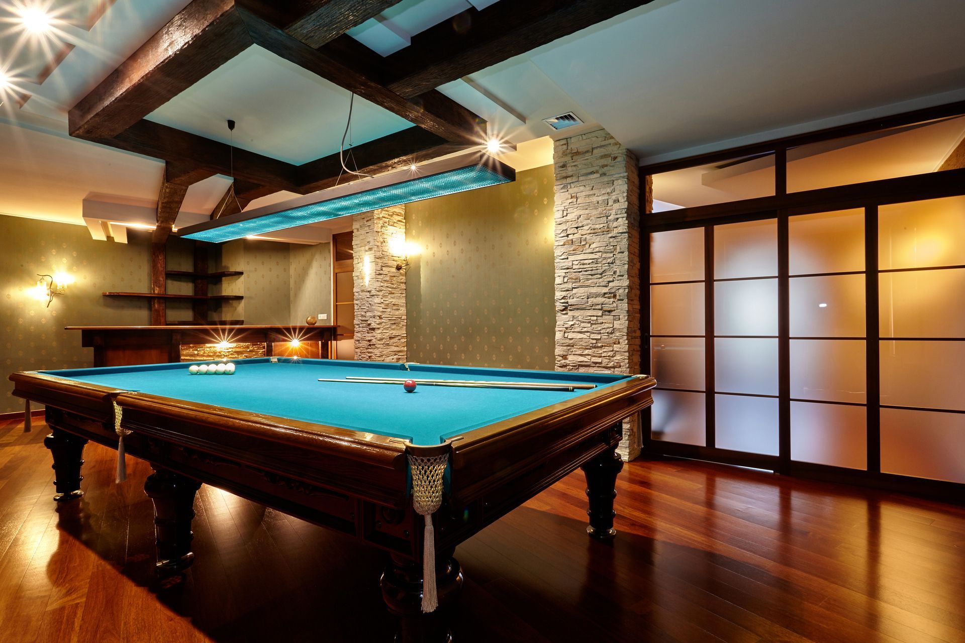 A pool table in a room with sliding glass doors