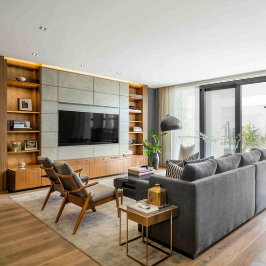 A living room with a couch , chairs , and a flat screen tv.