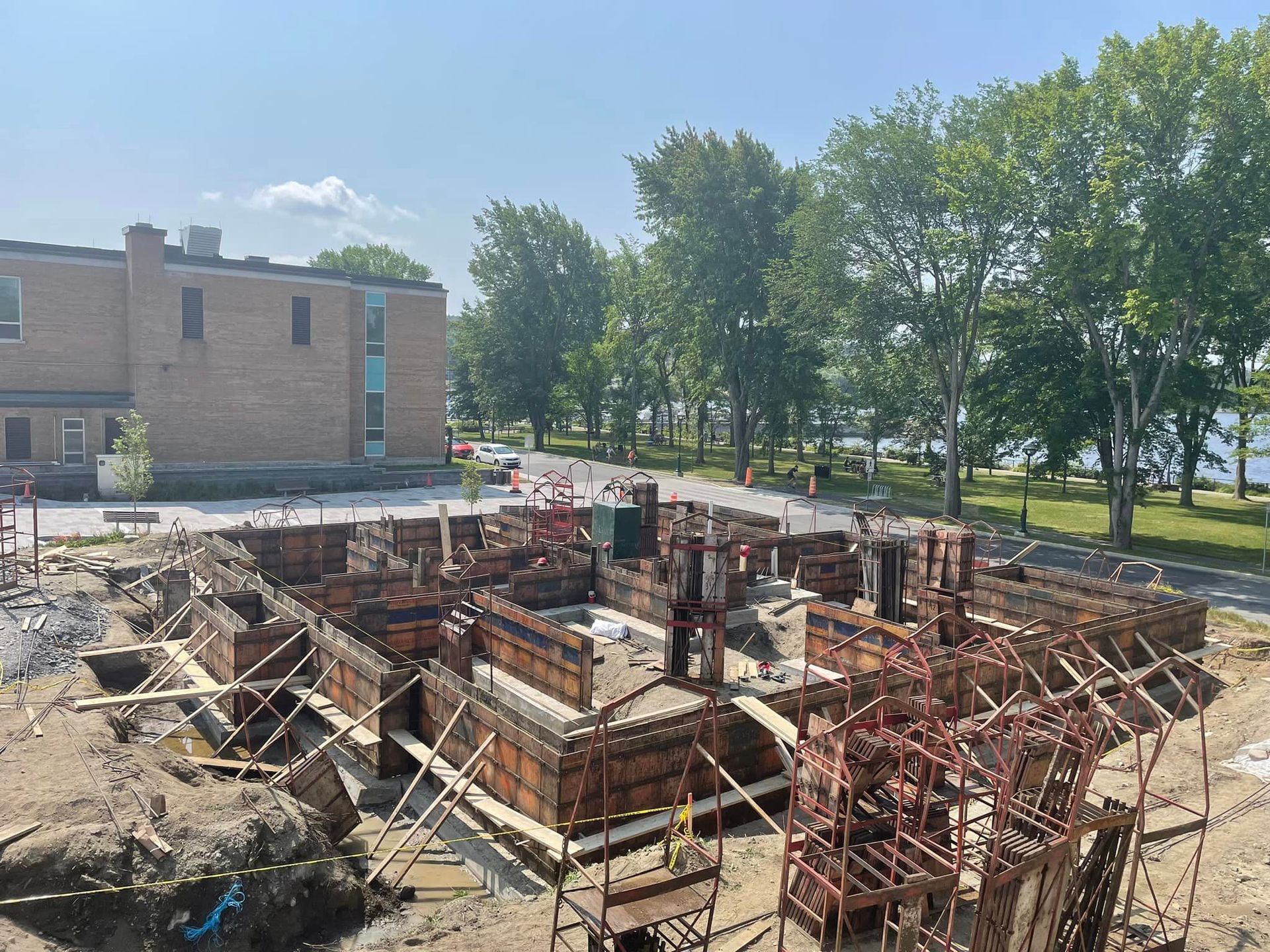 Un grand bâtiment est en construction à côté d'un plan d'eau.