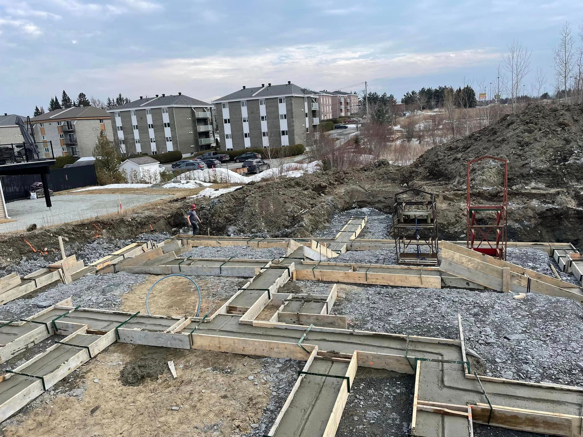 Un chantier avec beaucoup de béton et beaucoup de bâtiments en arrière-plan.