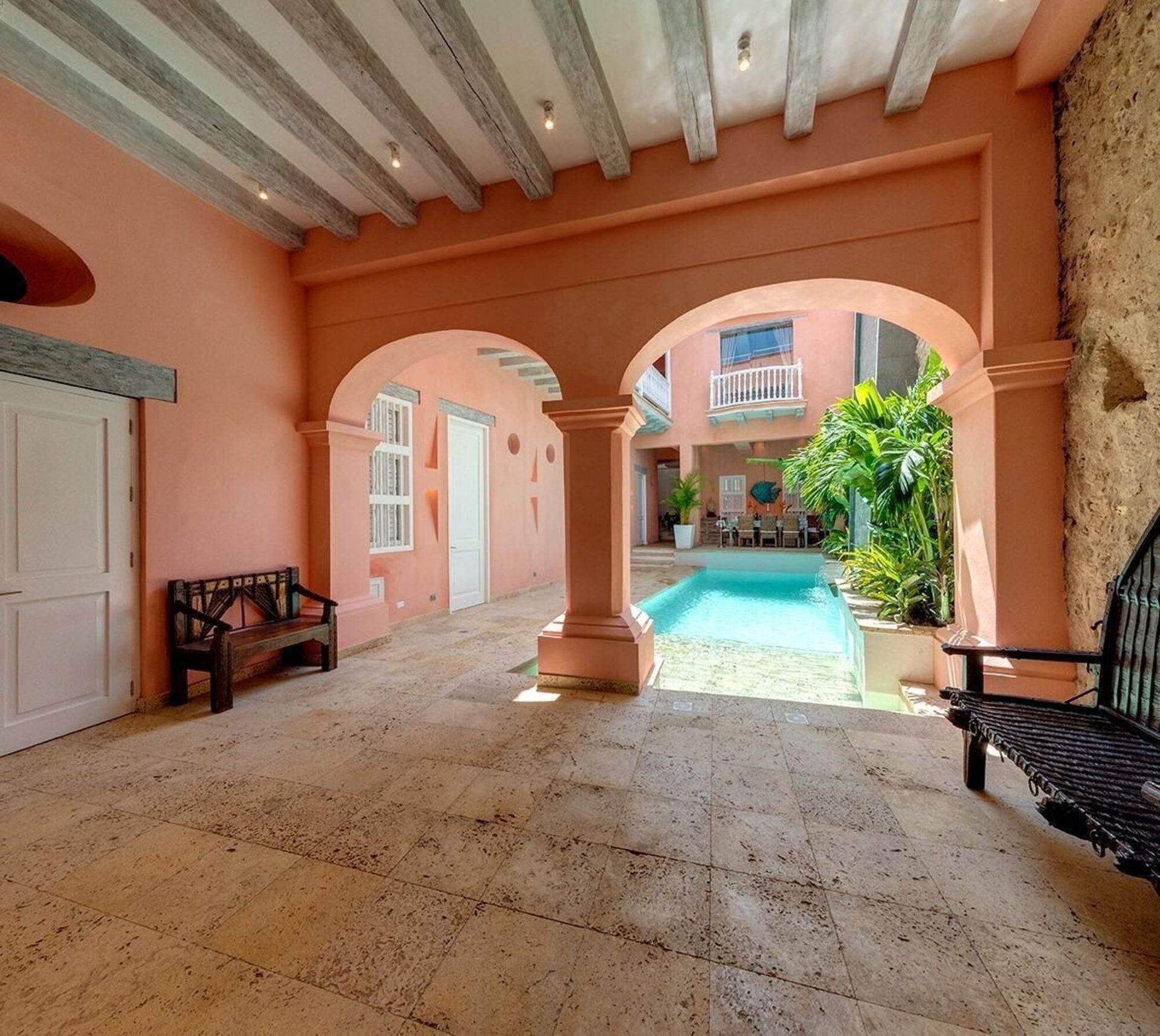 Una habitación con un banco y una piscina.