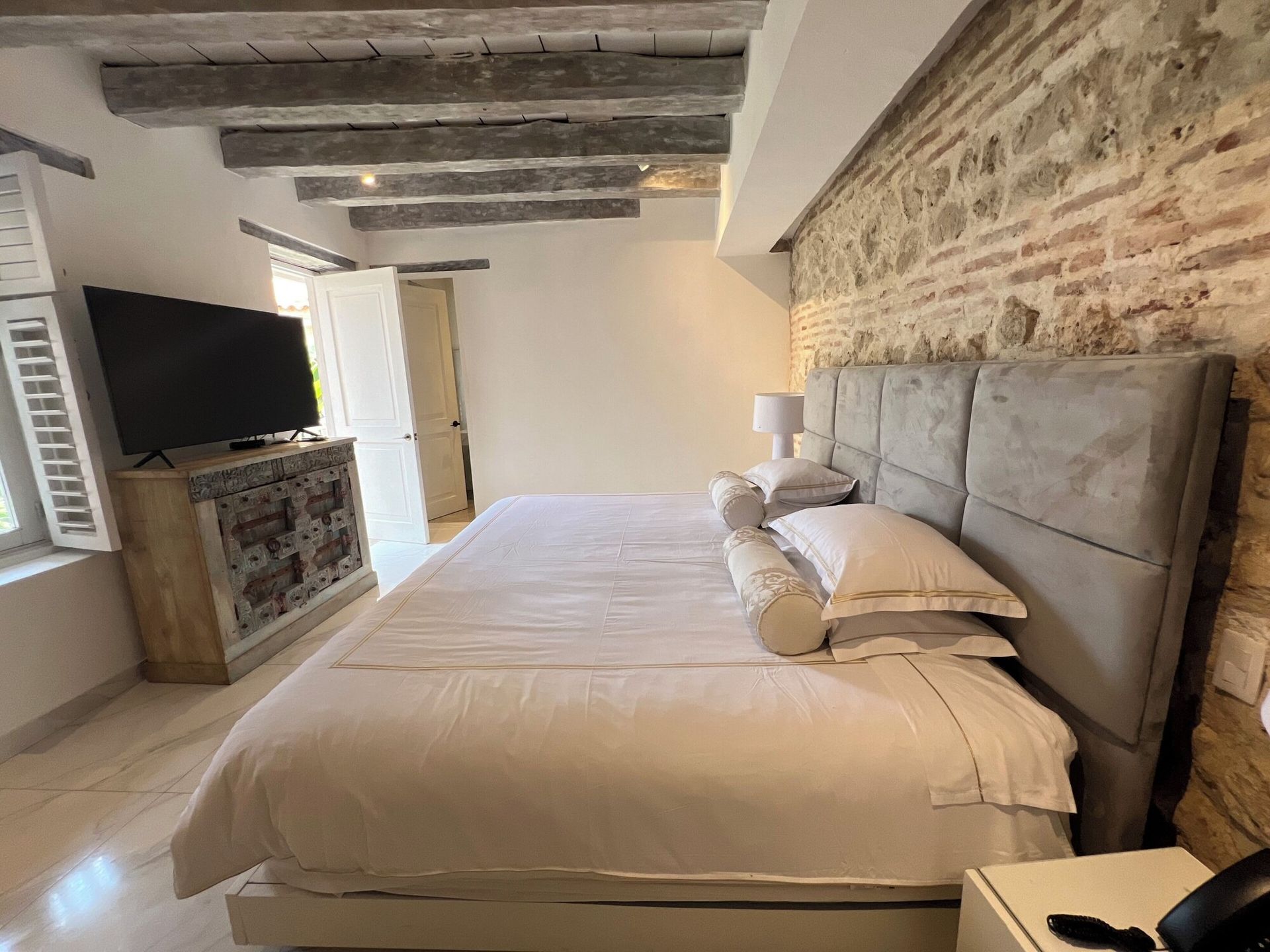 Un dormitorio con una cama king size y un televisor de pantalla plana.