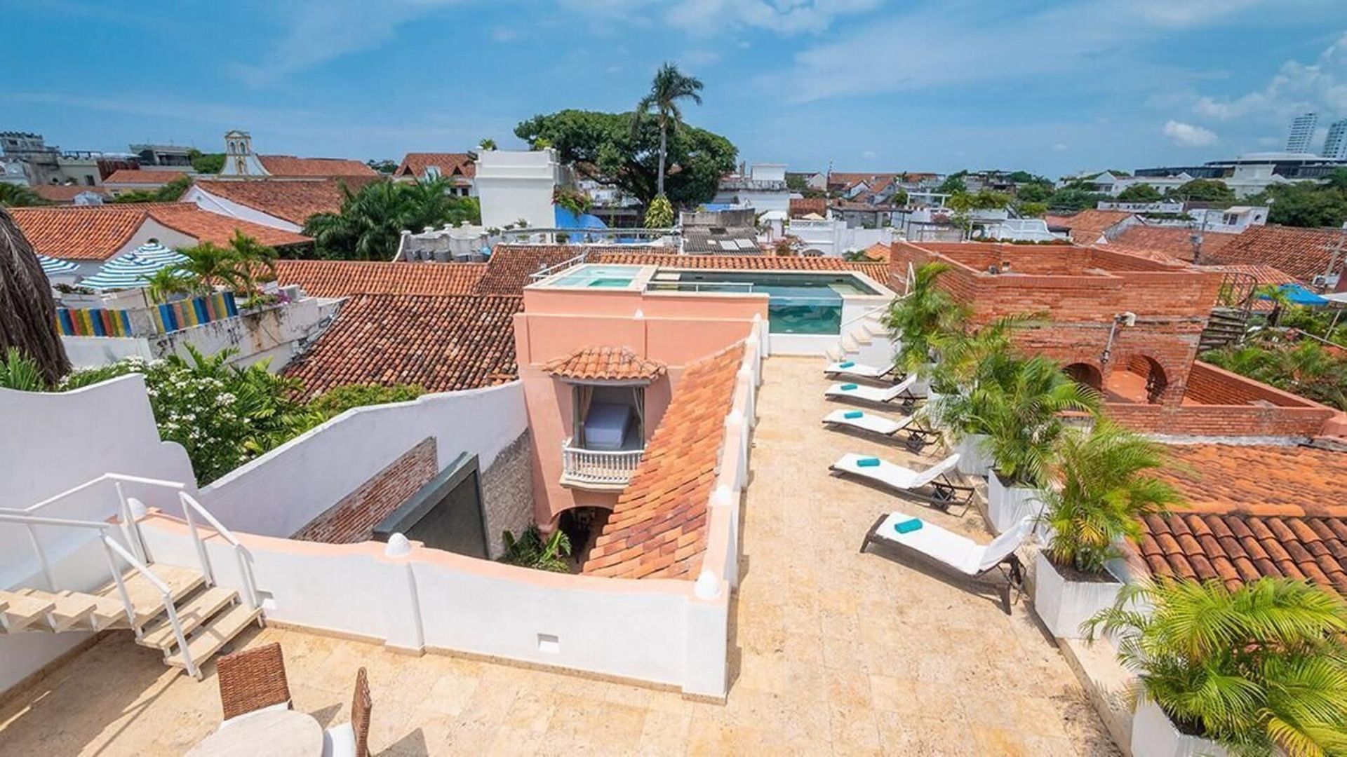Una vista aérea de una azotea con piscina y sillas.