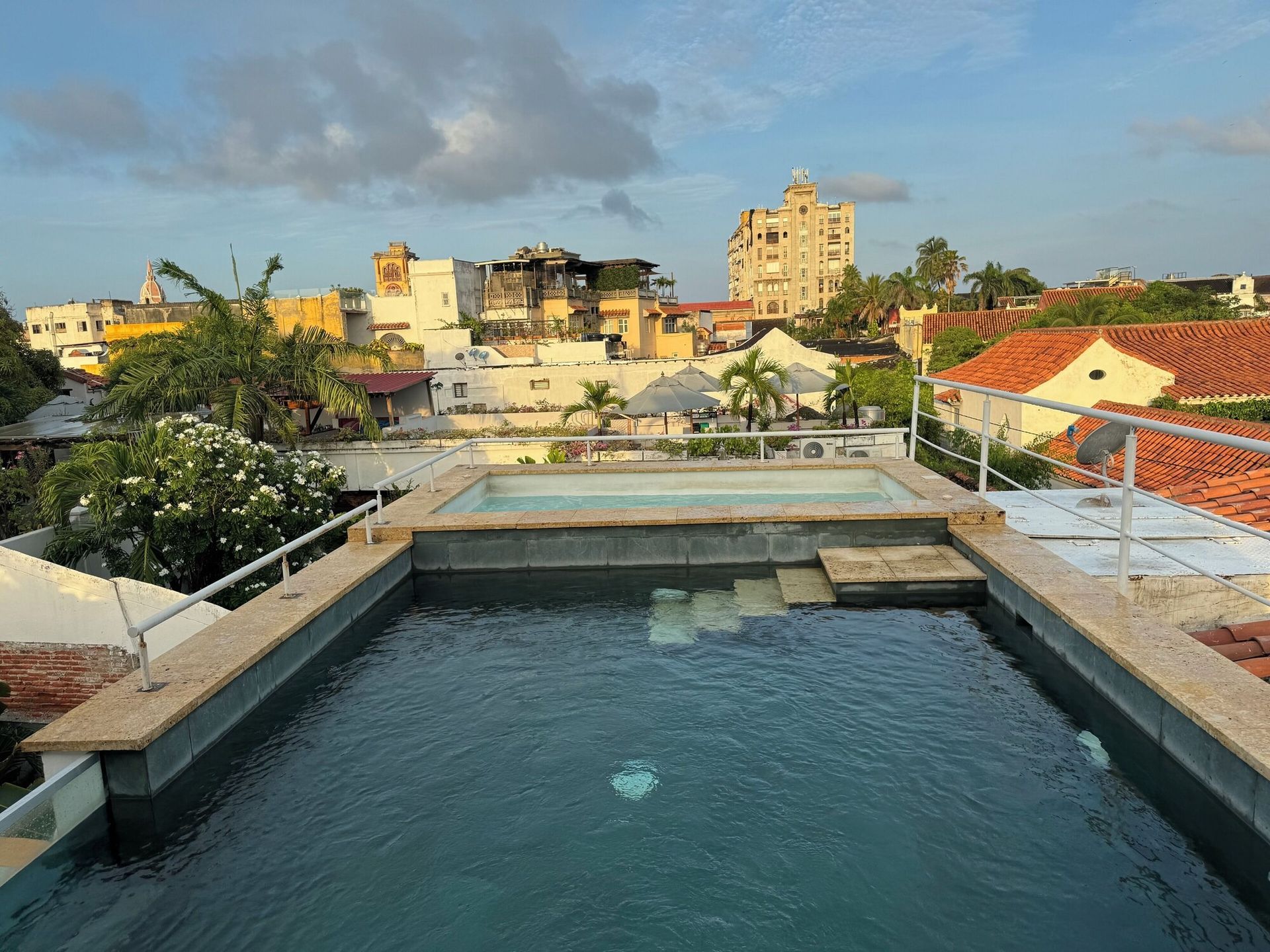 Una gran piscina en lo alto de un edificio con una ciudad al fondo.