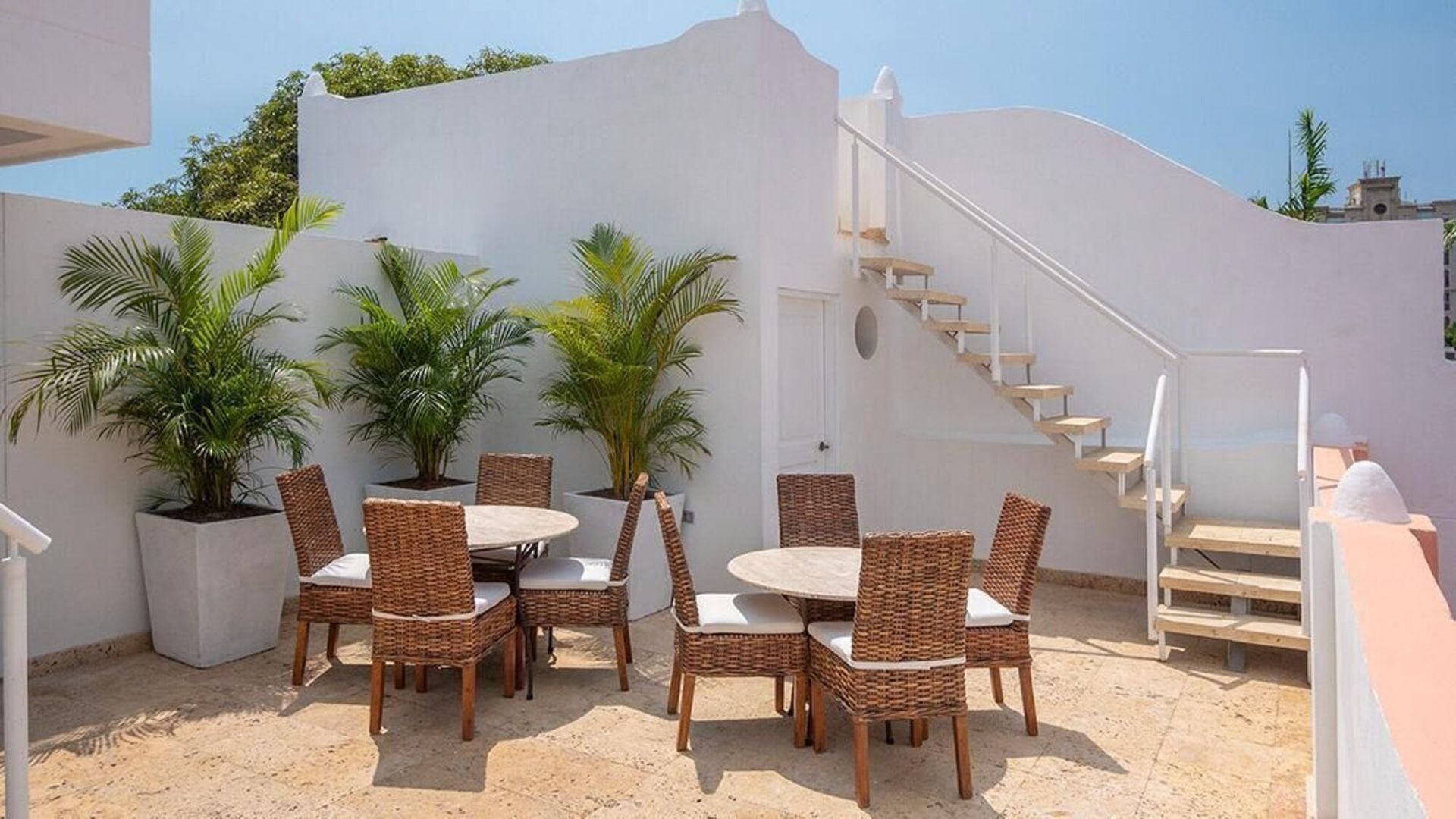 Un patio con mesa y sillas y escaleras.