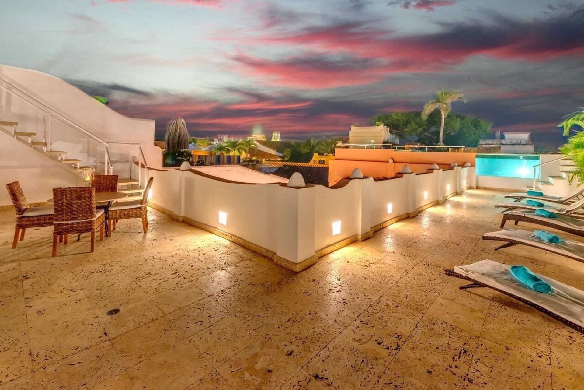 Una azotea con una mesa y sillas y una piscina.