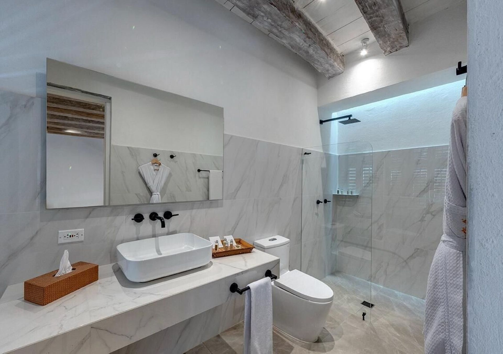 Un baño con lavabo, inodoro, espejo y ducha.