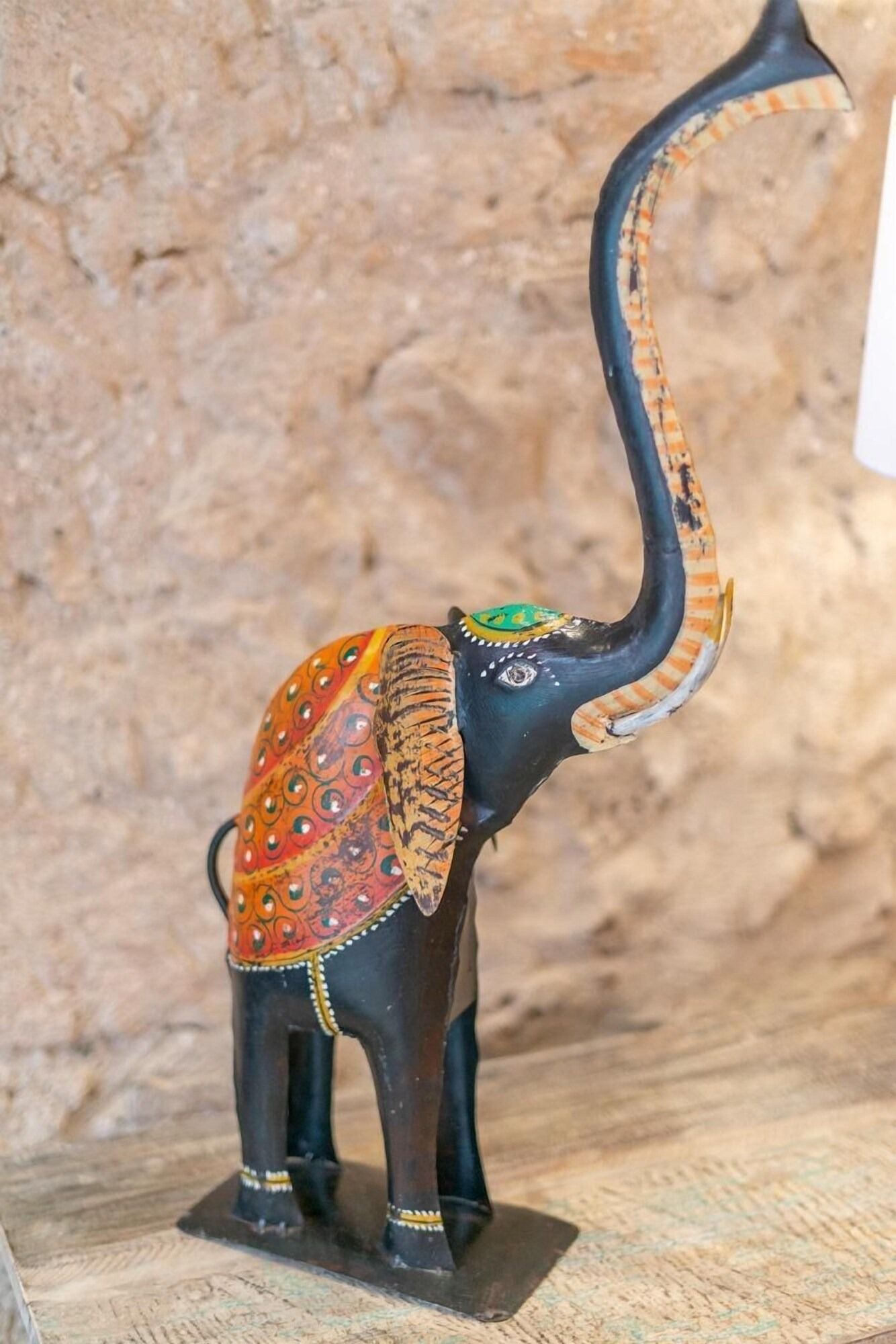 Una estatua de un elefante con una trompa larga está sentada sobre una mesa.