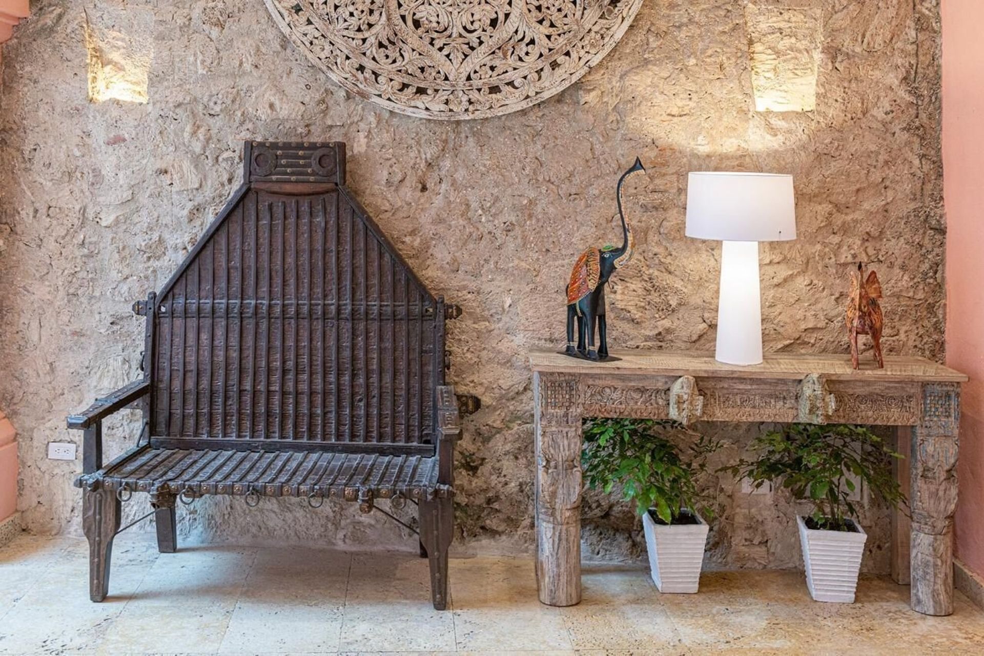 Un banco de madera está situado al lado de una mesa de madera frente a una pared de piedra.