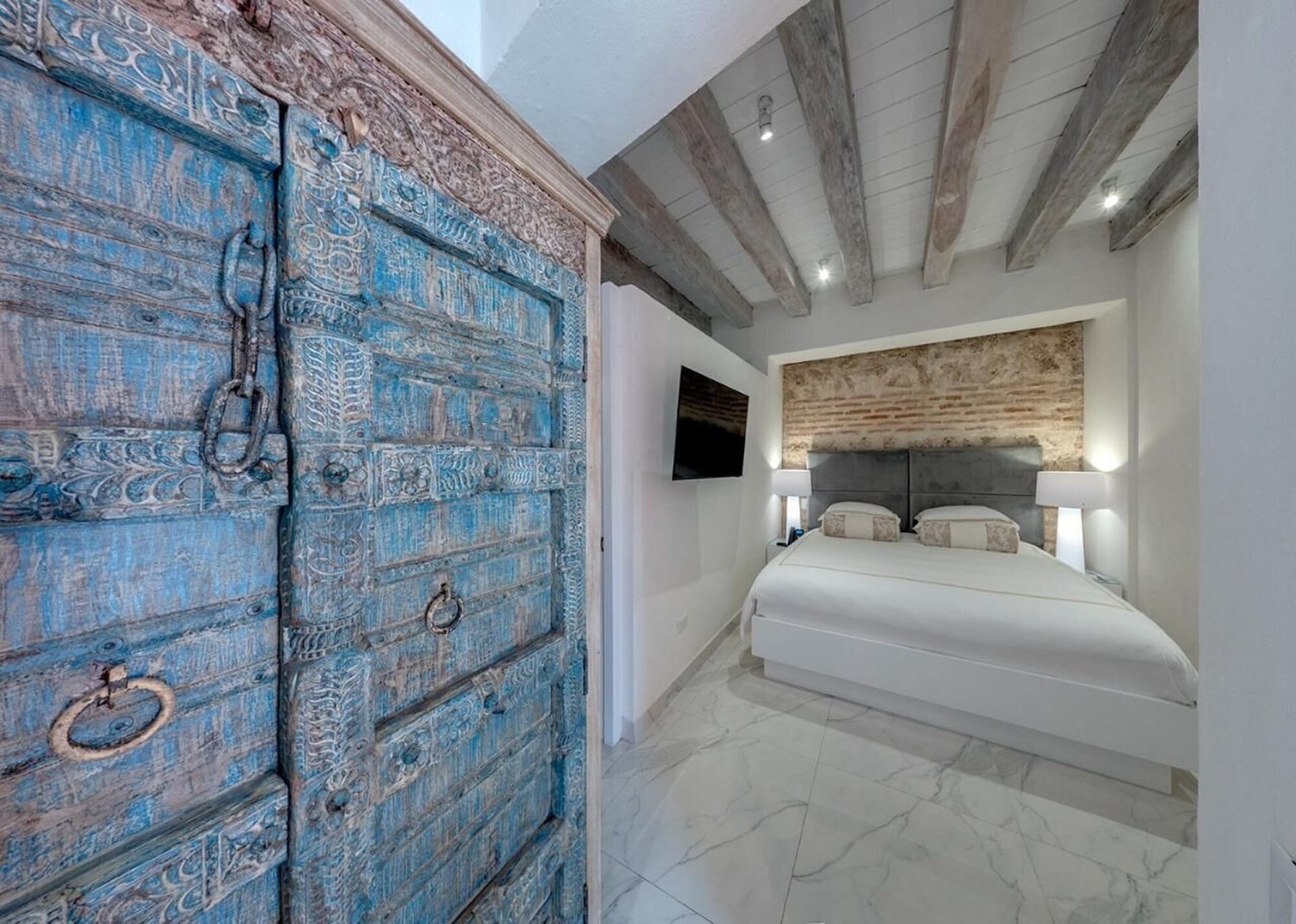 Un dormitorio con una cama y una puerta azul.