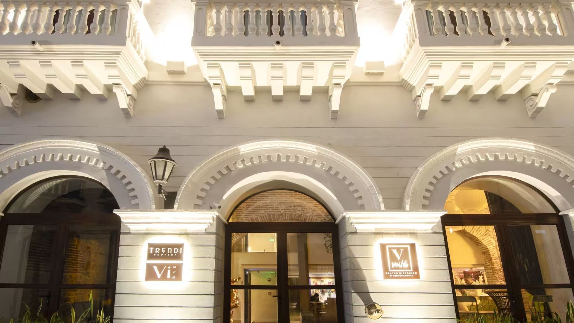 Un gran edificio blanco con ventanas y balcones arqueados.