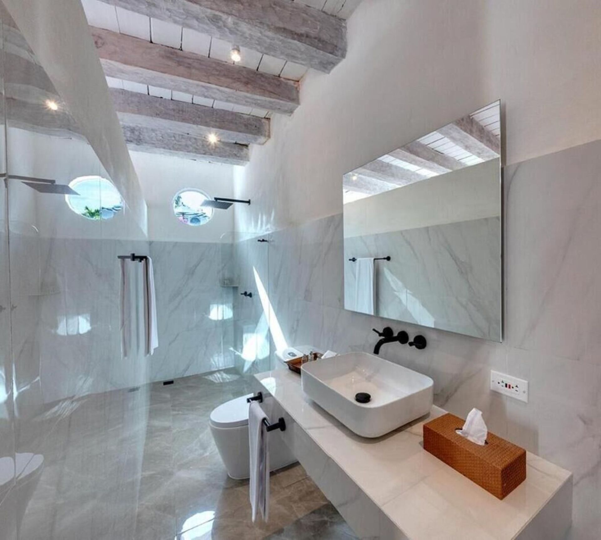 Un baño con inodoro, lavabo y espejo.