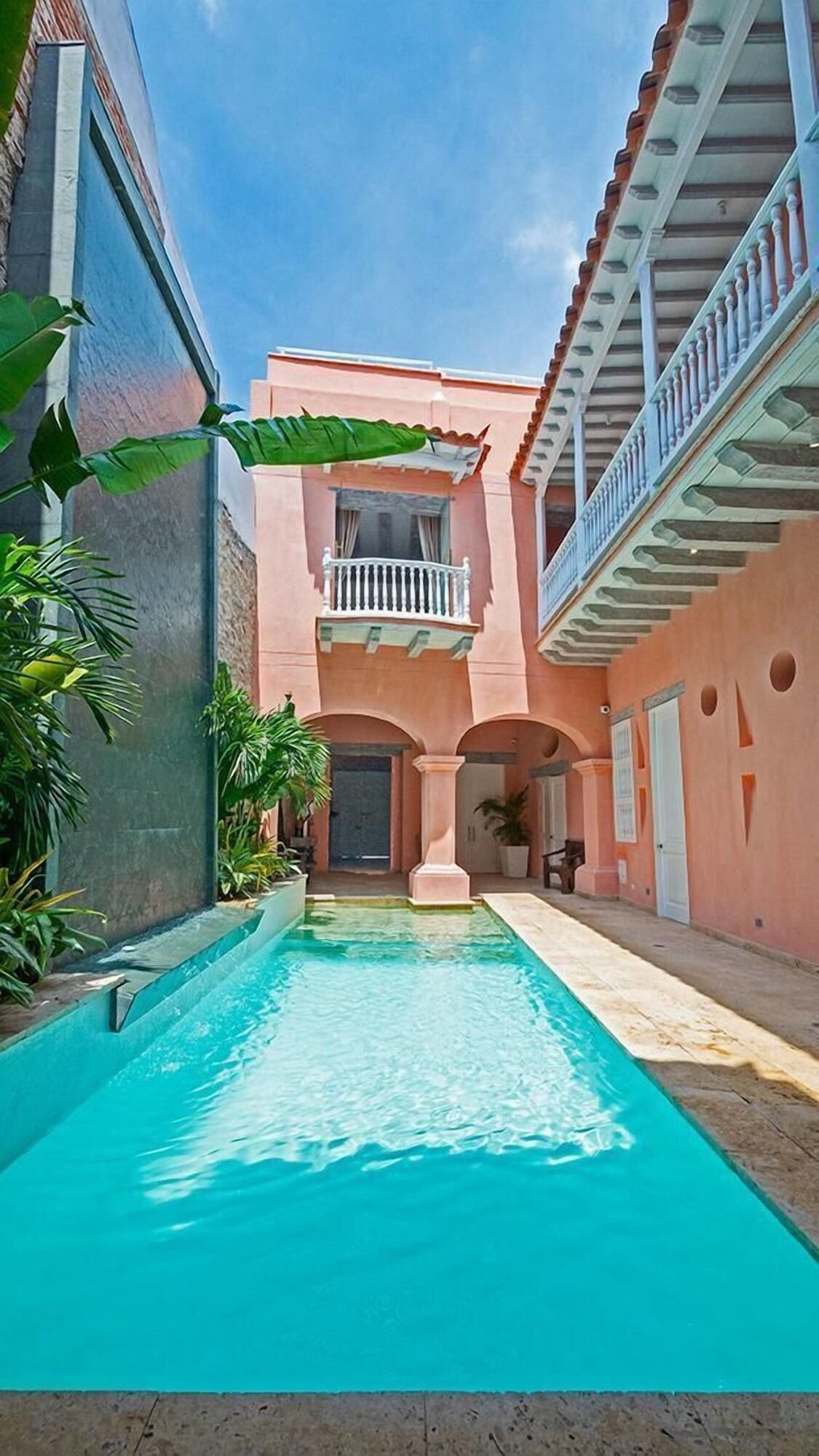Una gran piscina en medio de un edificio rosa.