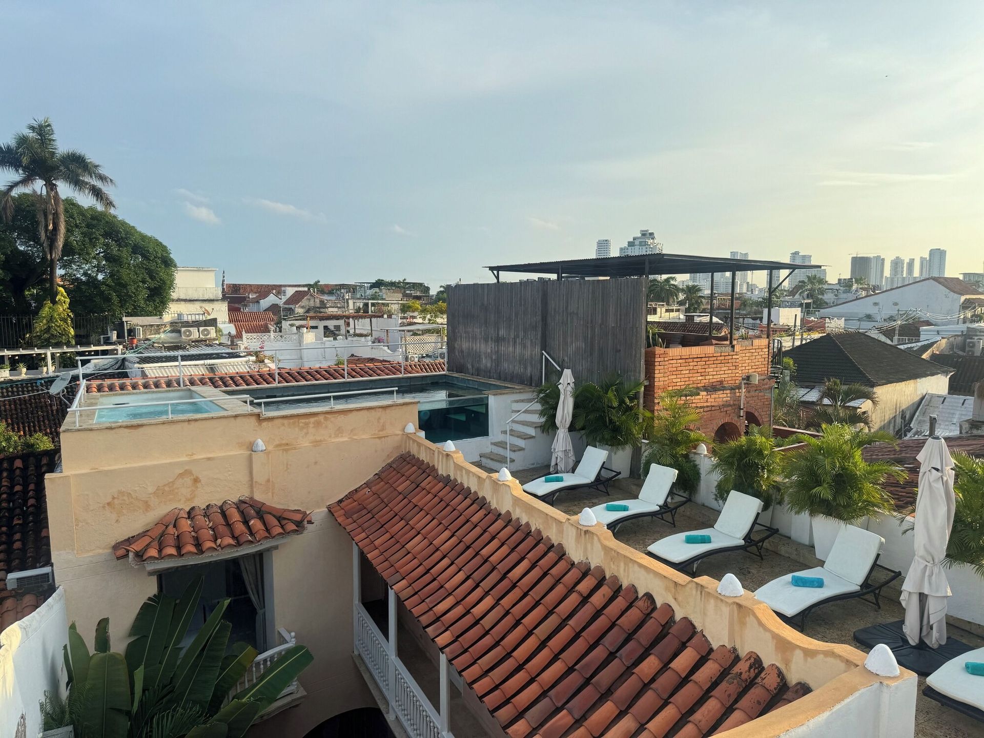 El techo de un edificio con una piscina y tumbonas en él.