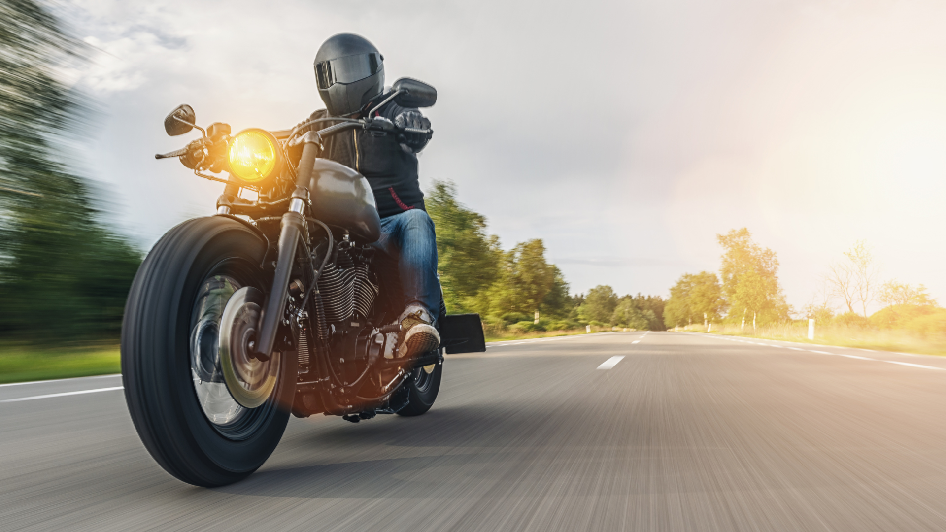 a man is riding a motorcycle down a road .