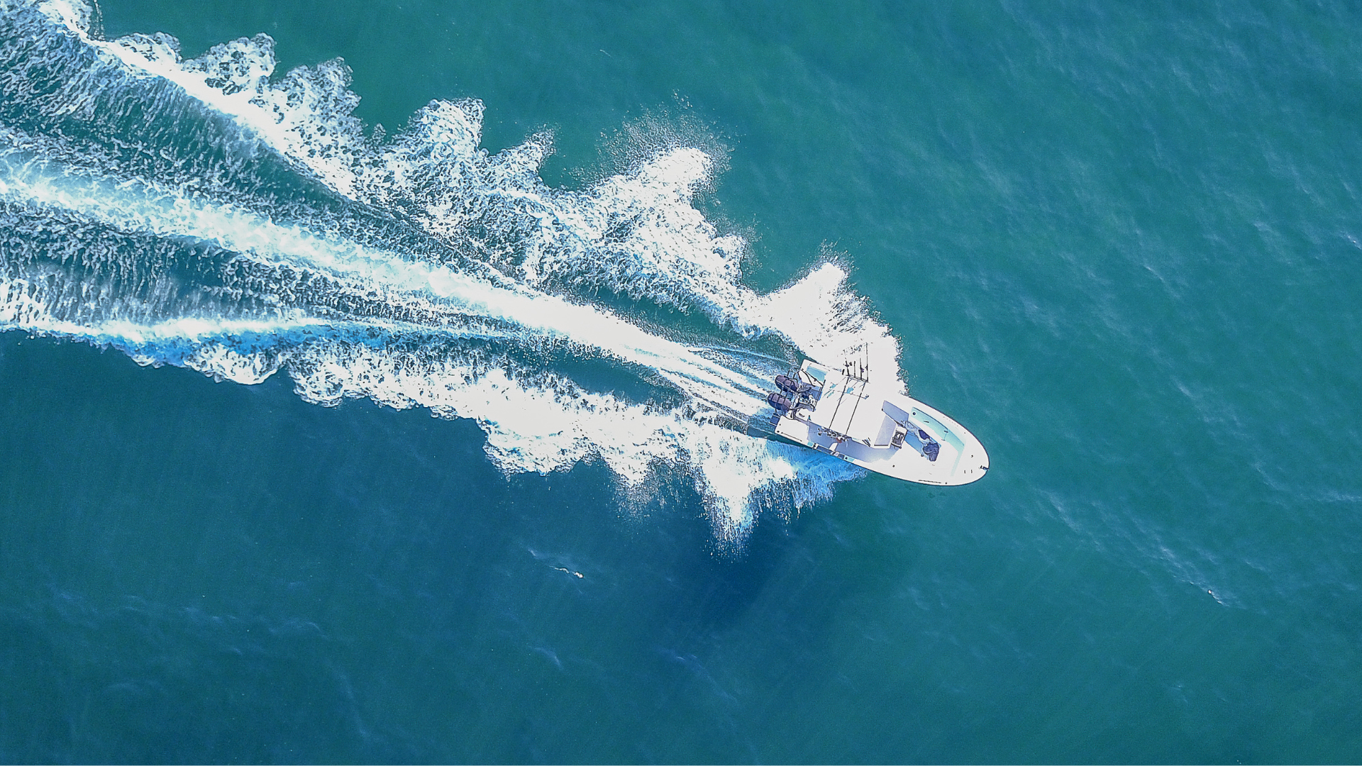 an aerial view of a boat floating on top of a body of water .