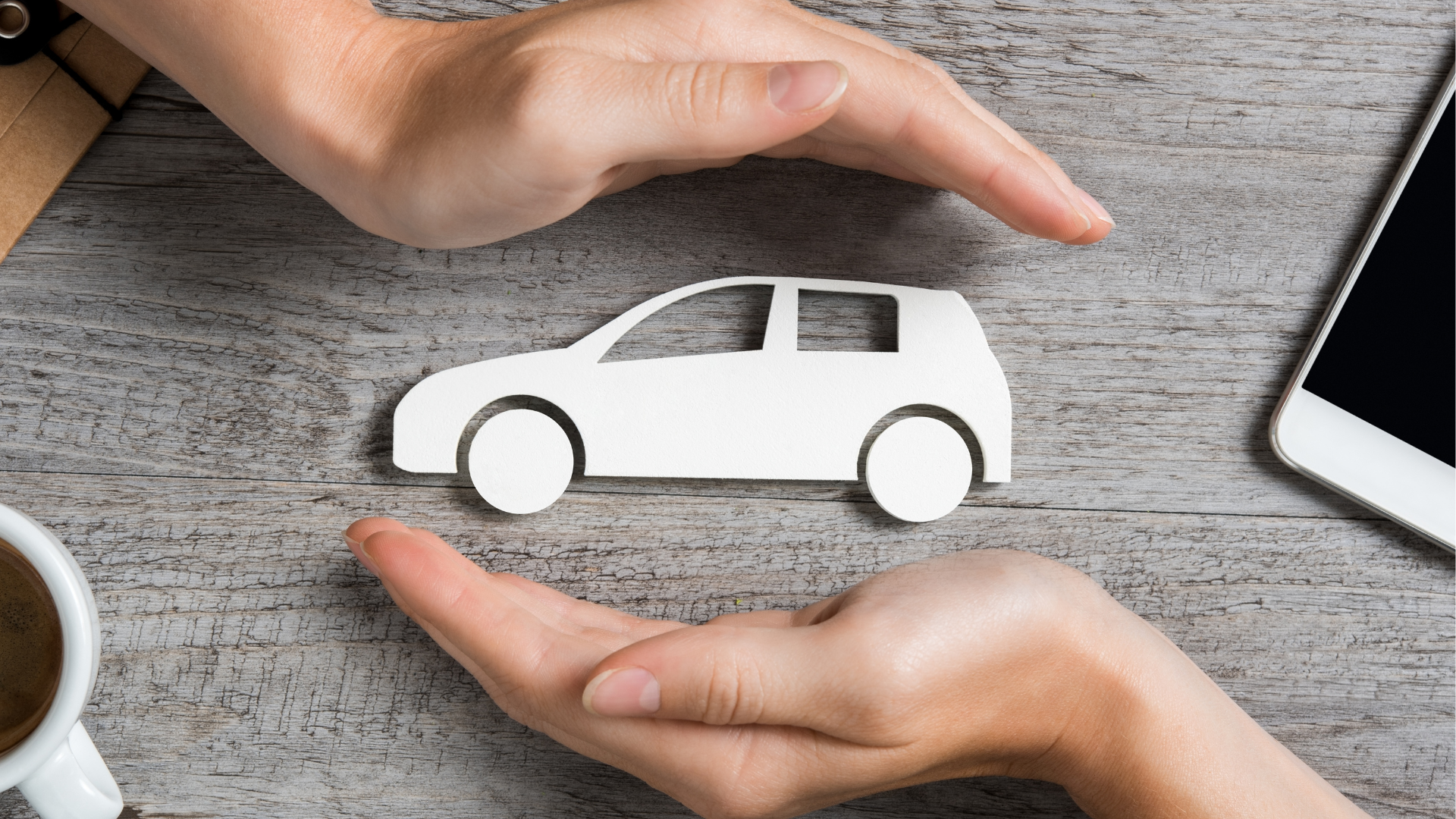 a person is holding a paper car in their hands .