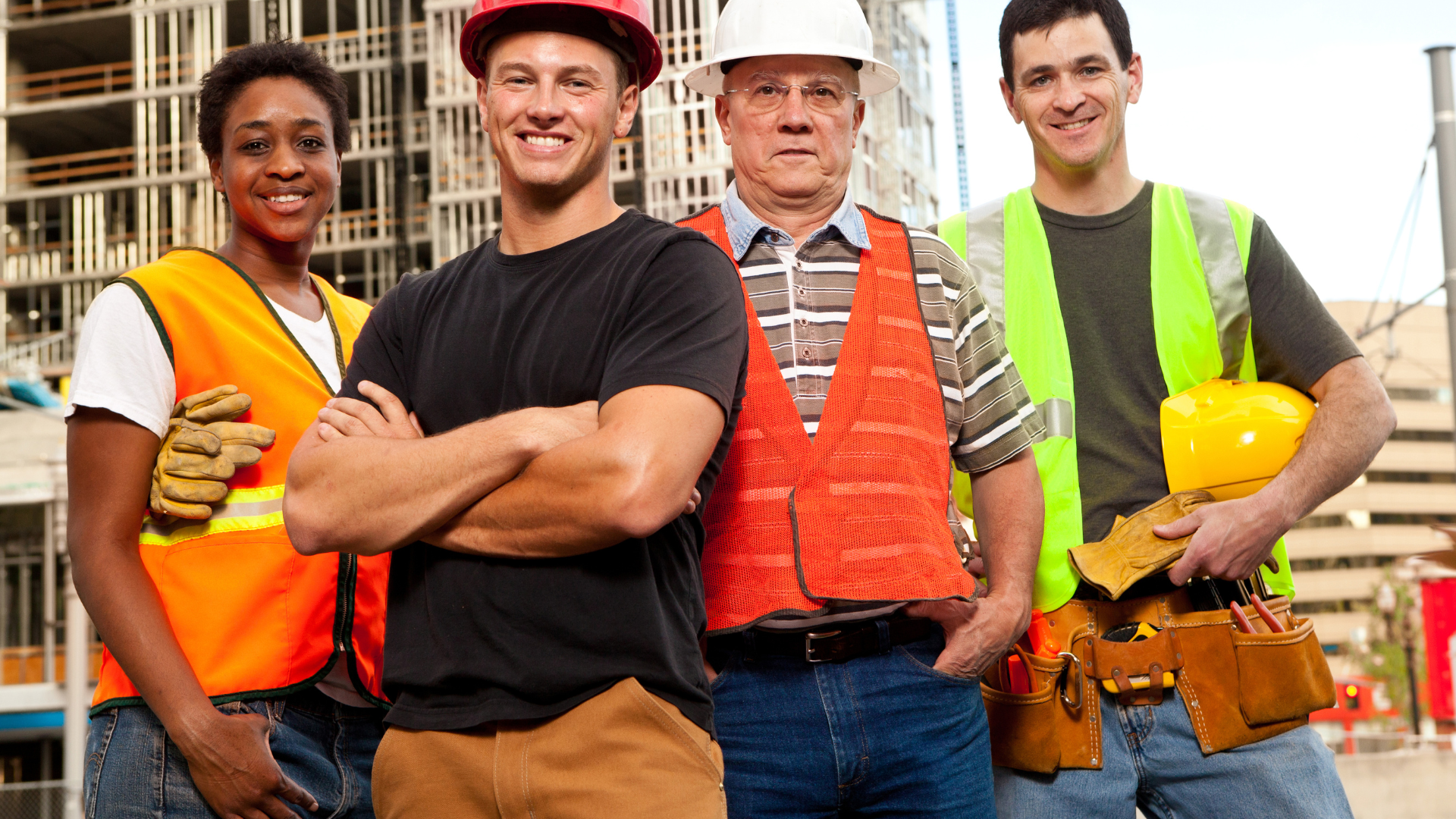 A group of construction workers are posing for a picture on a construction site.