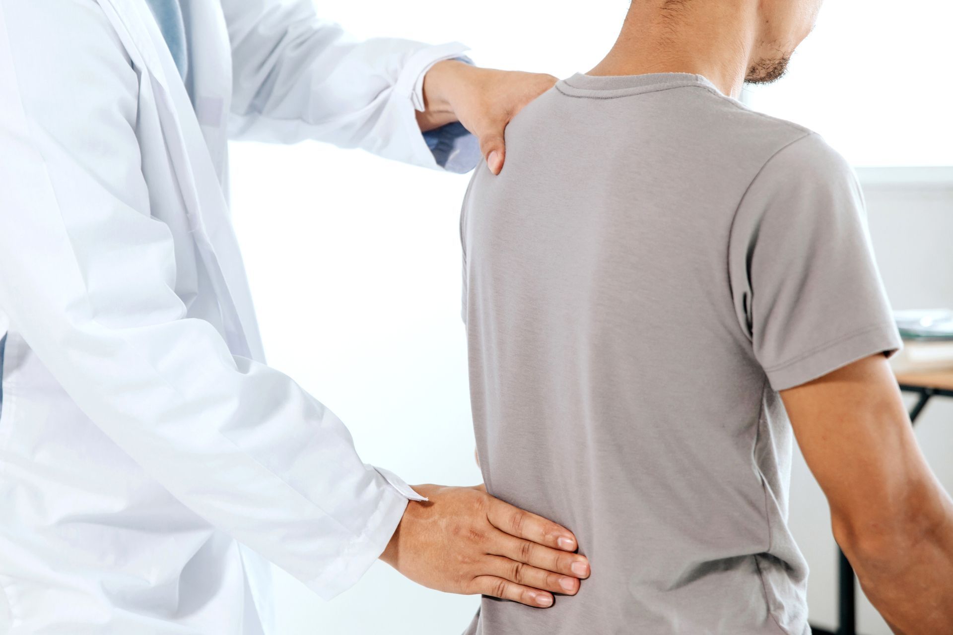 A doctor provides a back massage to a man, emphasizing pain relief treatment in Wildwood Lake, TN.