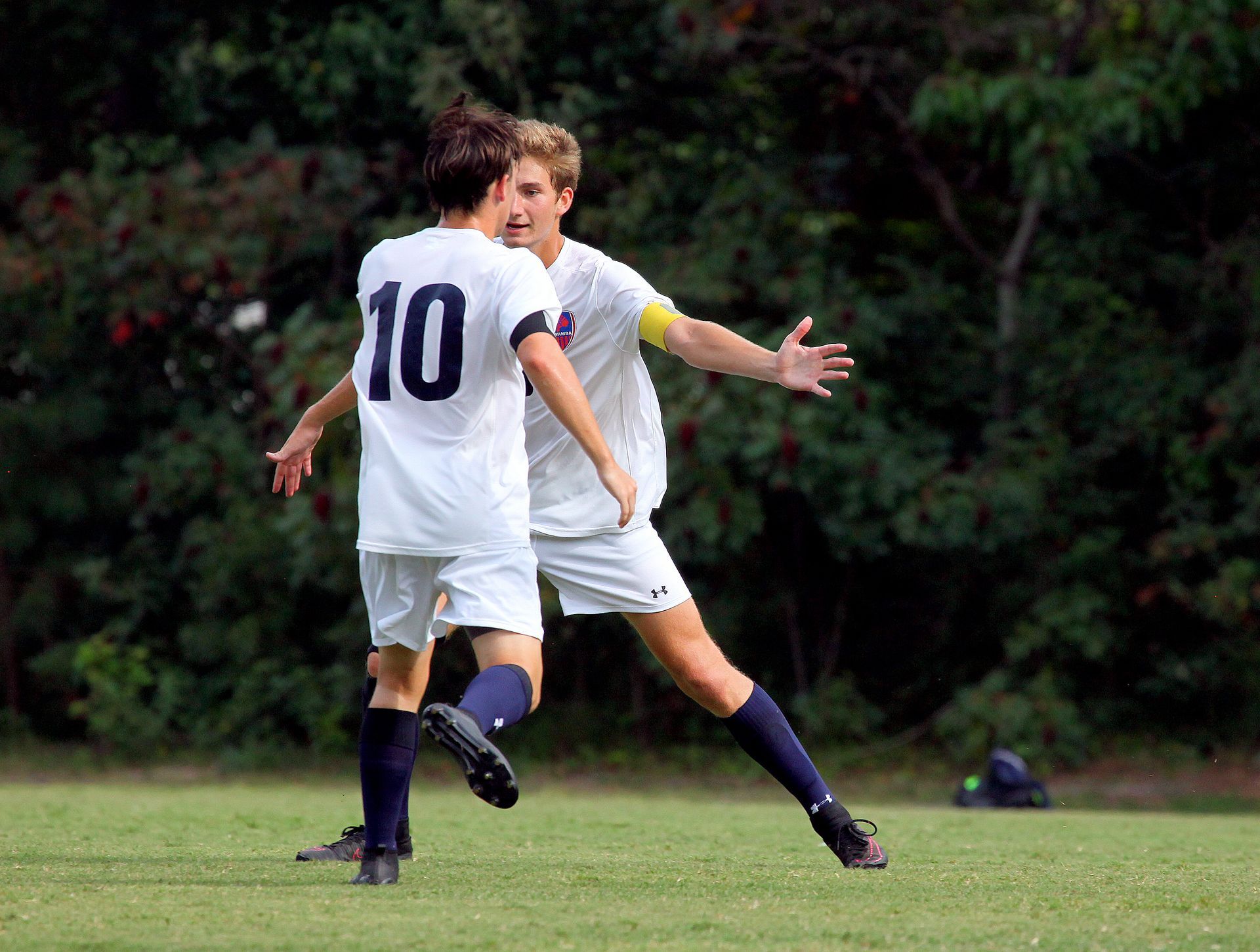 A soccer player with the number 10 on his back is hugging another player