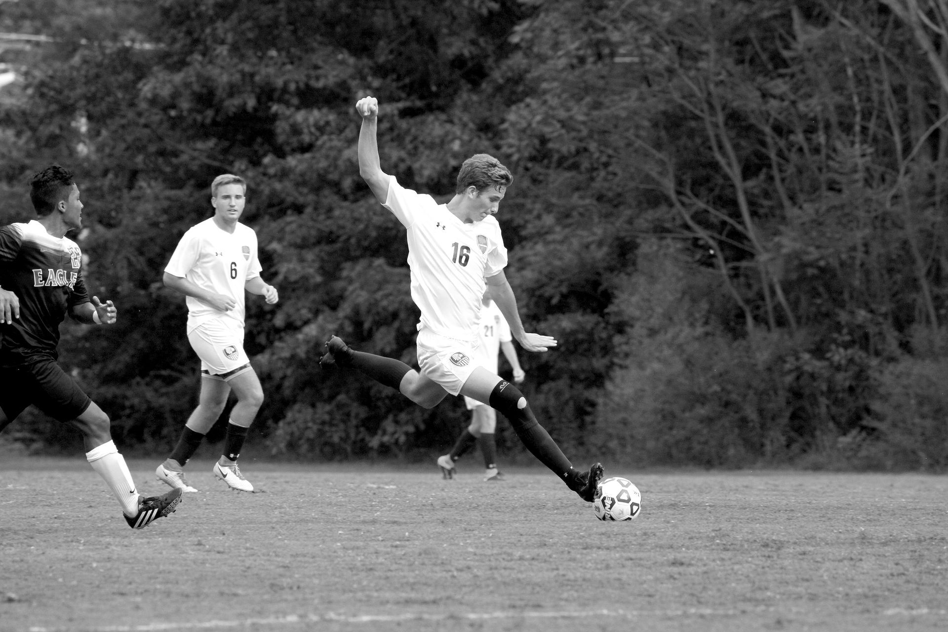 A group of soccer players are playing a game on a field.