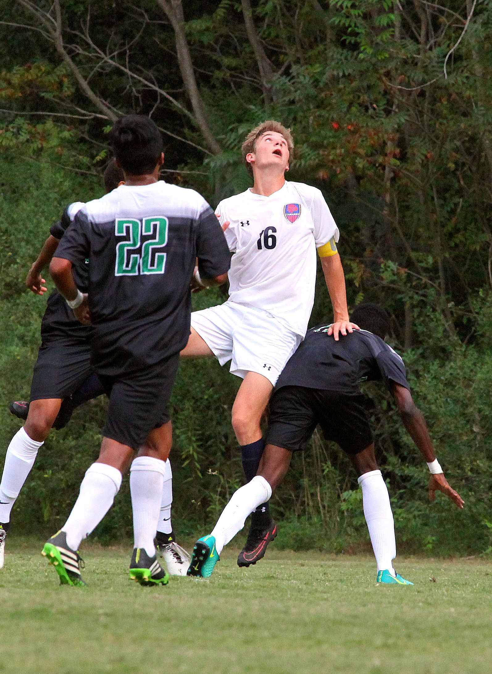 A group of soccer players are playing a game on a field.