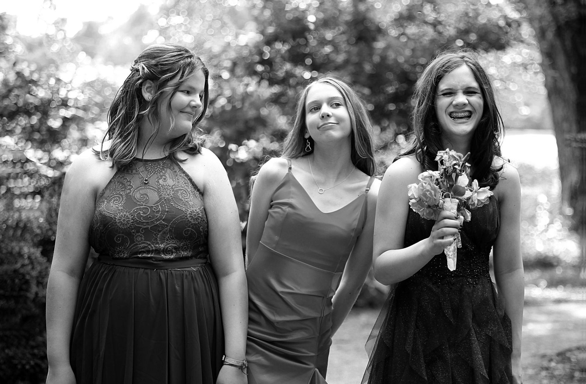 Three bridesmaids are standing next to each other in a black and white photo.
