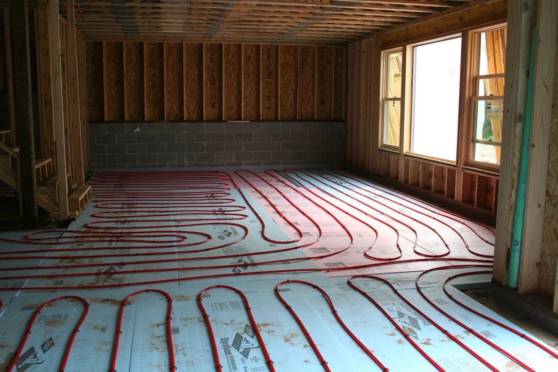 A water heater is hanging from the ceiling in a basement.