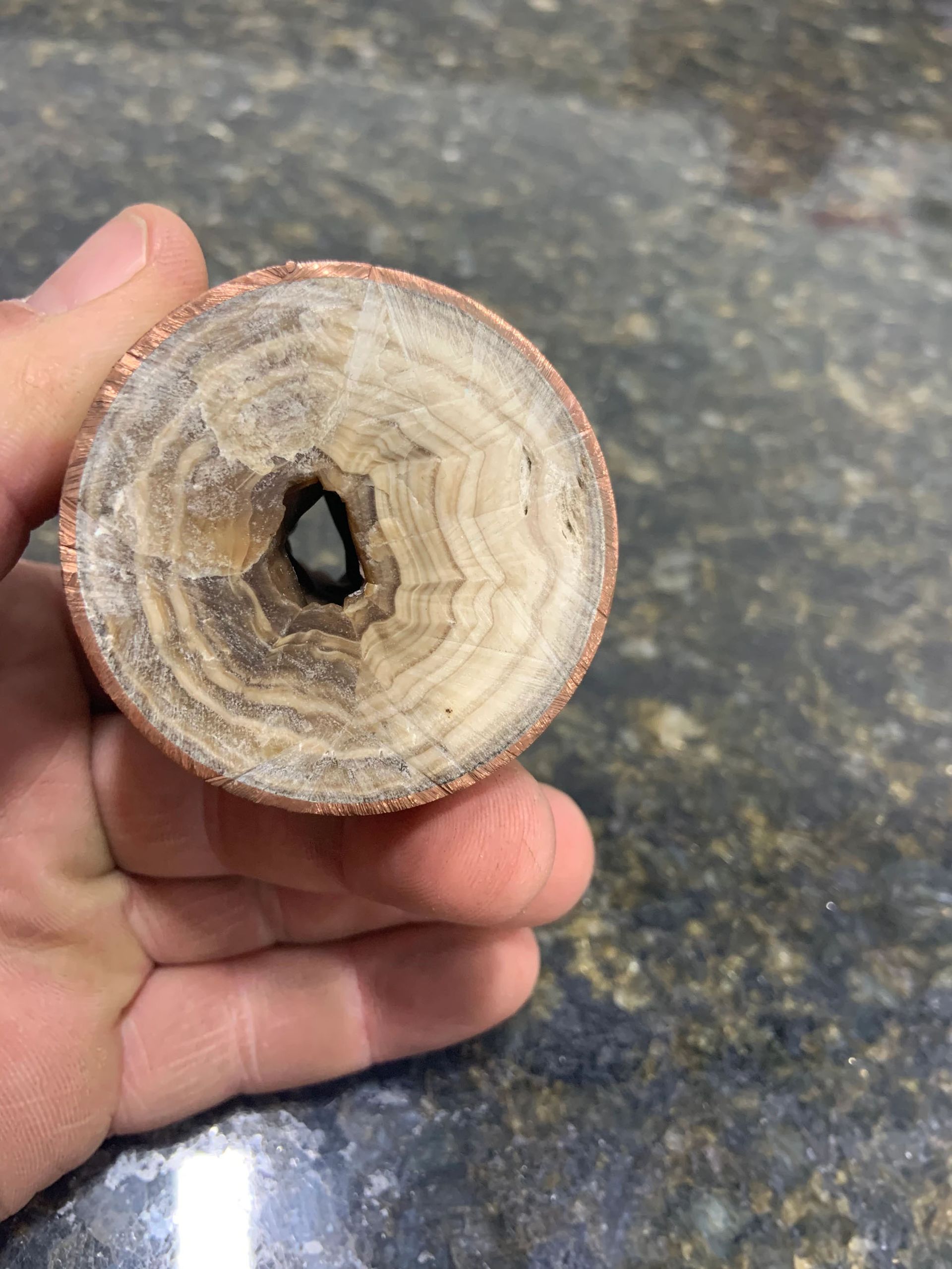 A water heater is hanging from the ceiling in a basement.