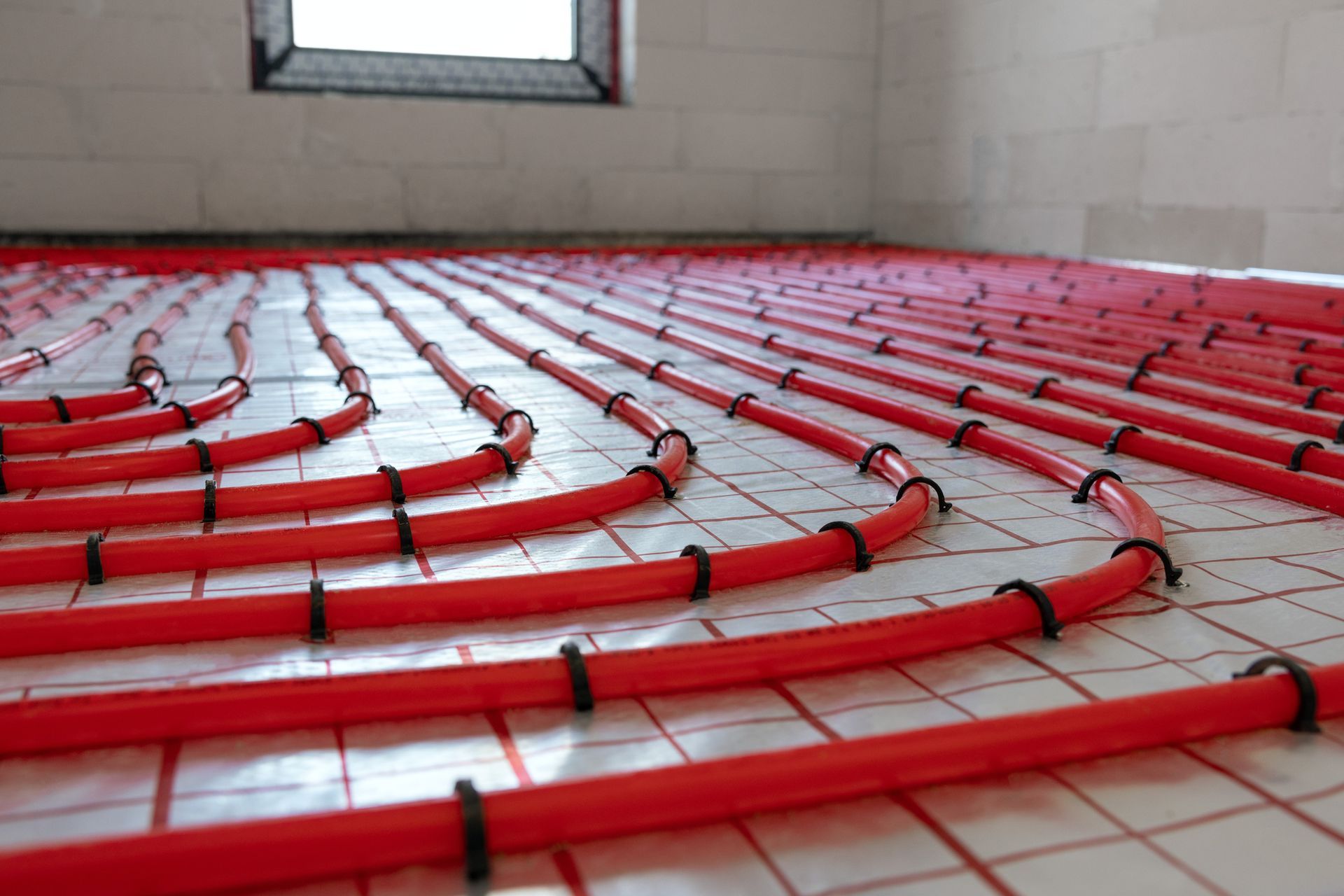 A room with a lot of red pipes on the floor.
