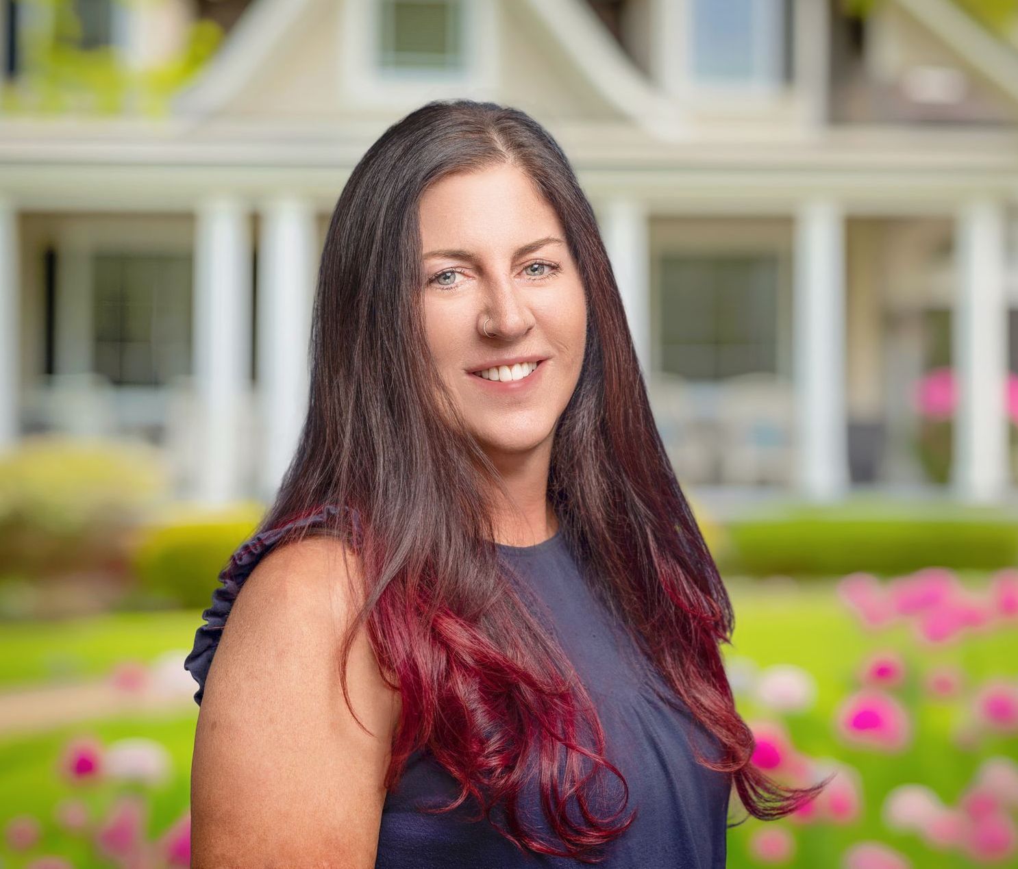 A woman is sitting on a chair in front of a brick wall. Ashley Kersey Realtor