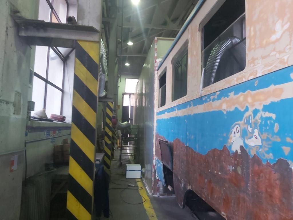 Un treno in un garage con un palo a strisce gialle e nere