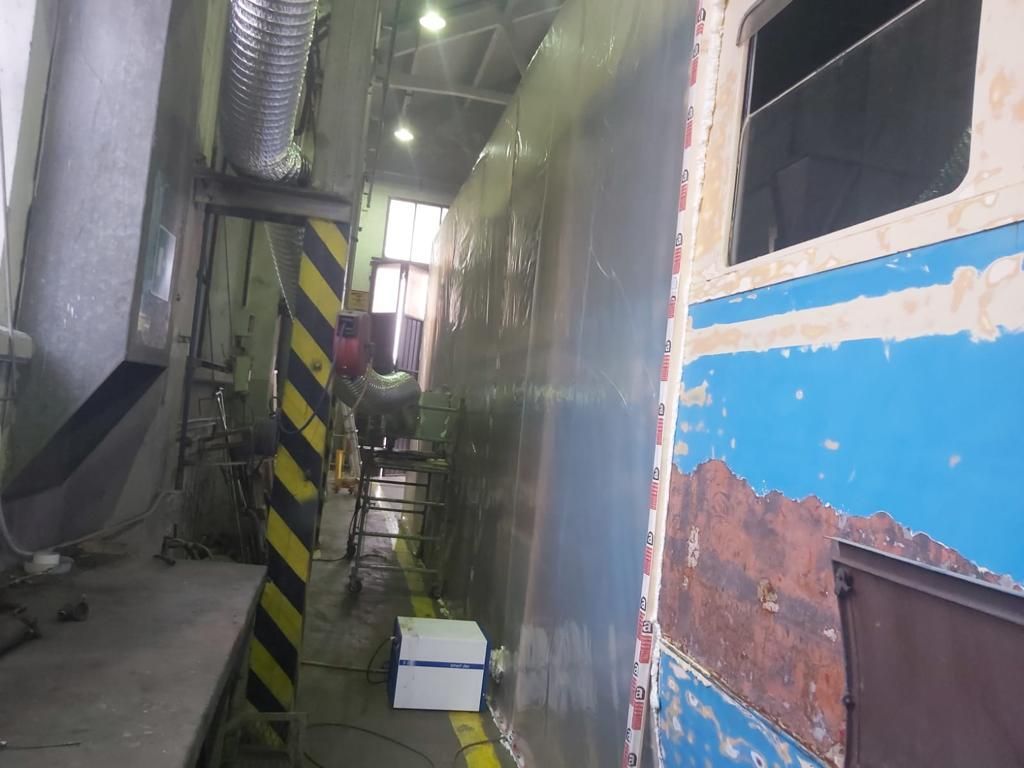 Un uomo sta lavorando su un muro in una fabbrica.