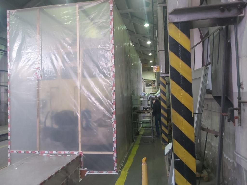 Un uomo è in piedi in una stanza ricoperta di plastica.