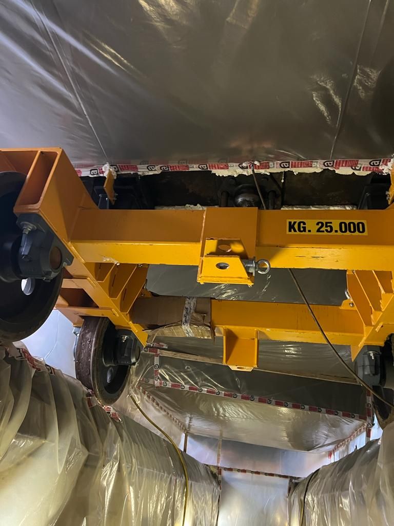 Una gru gialla è appesa al soffitto di un edificio.