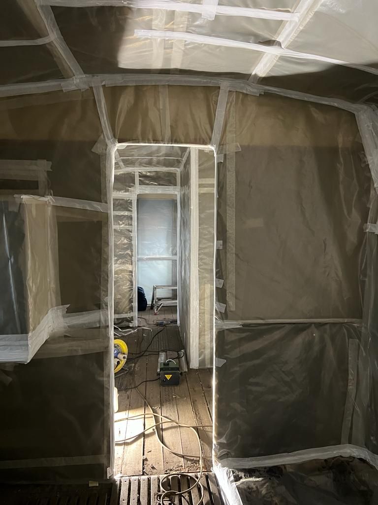 Una stanza con una porta e pareti ricoperte di plastica.