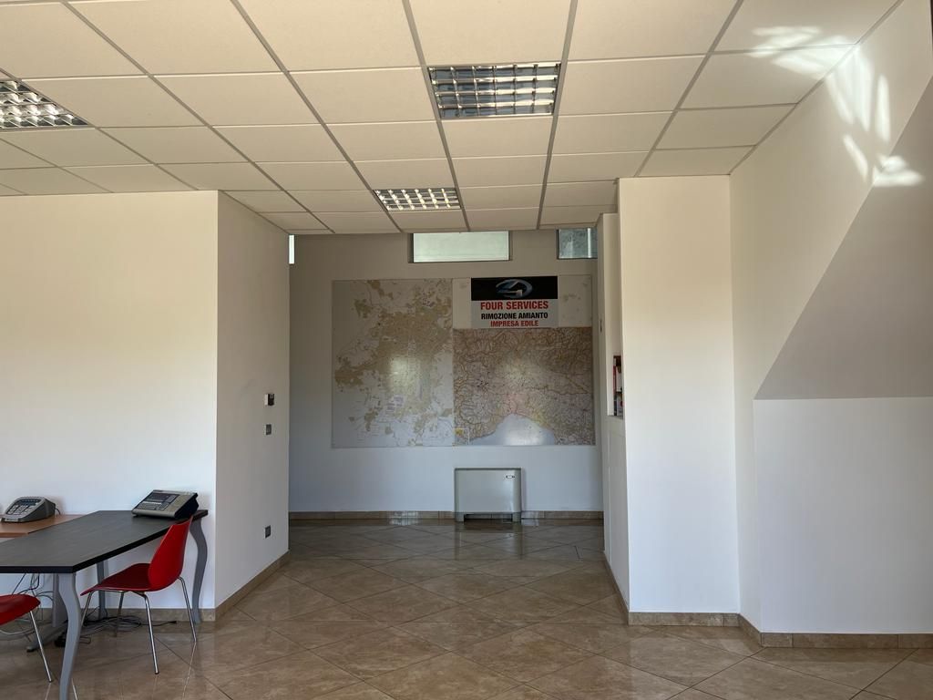 Una stanza con tavolo e sedie e una mappa sul muro