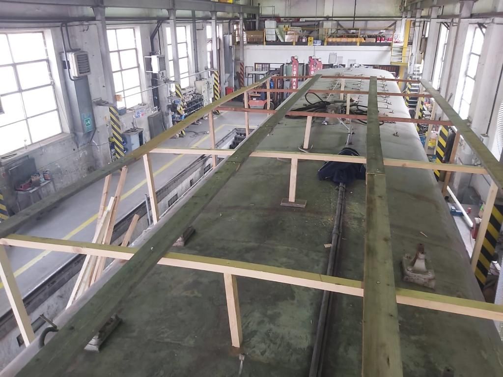 In una fabbrica si sta costruendo una grande struttura in legno.