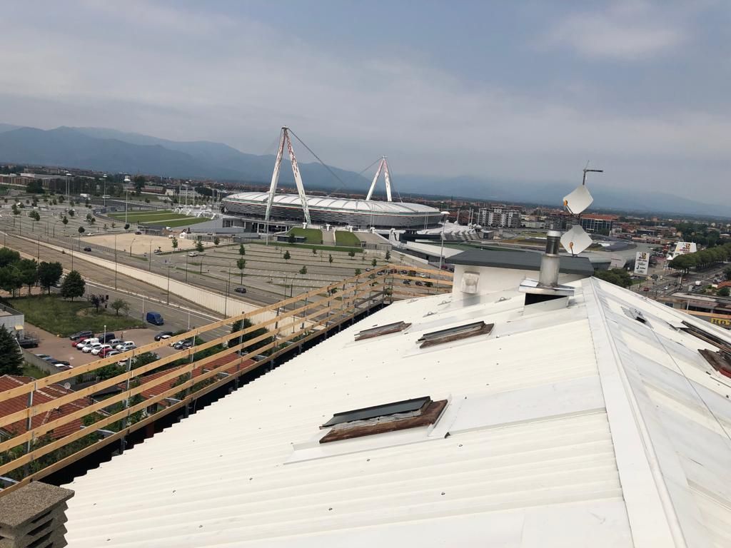 Una veduta aerea di un tetto bianco con uno stadio sullo sfondo