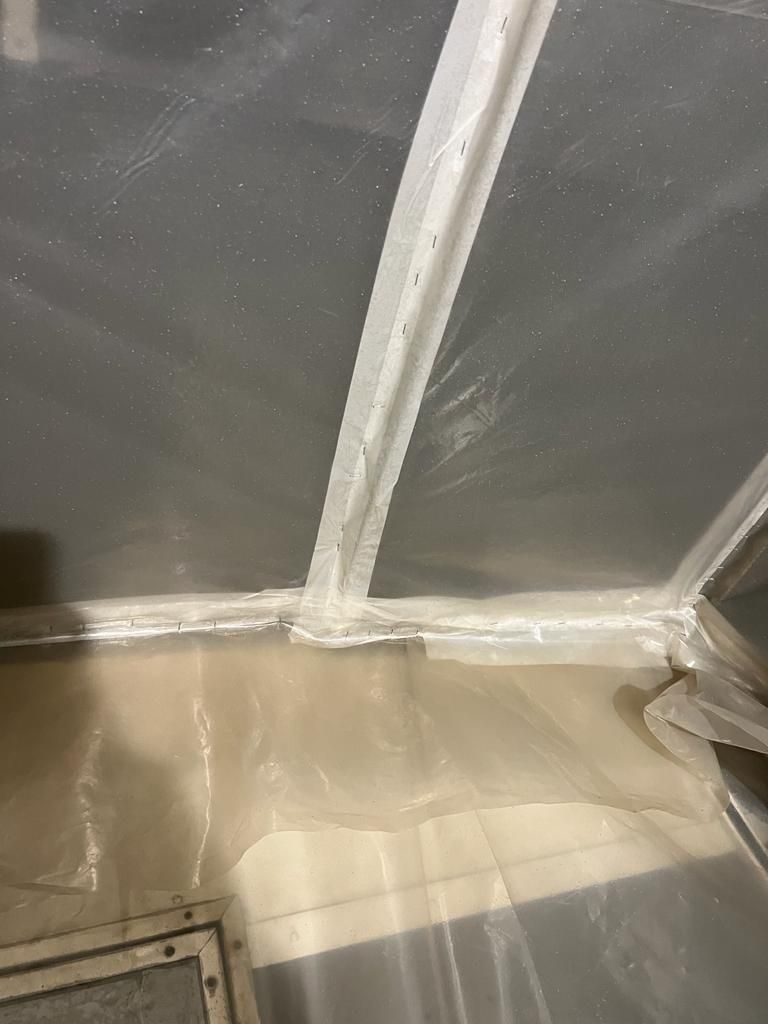 Un telo di plastica copre il soffitto di una stanza.