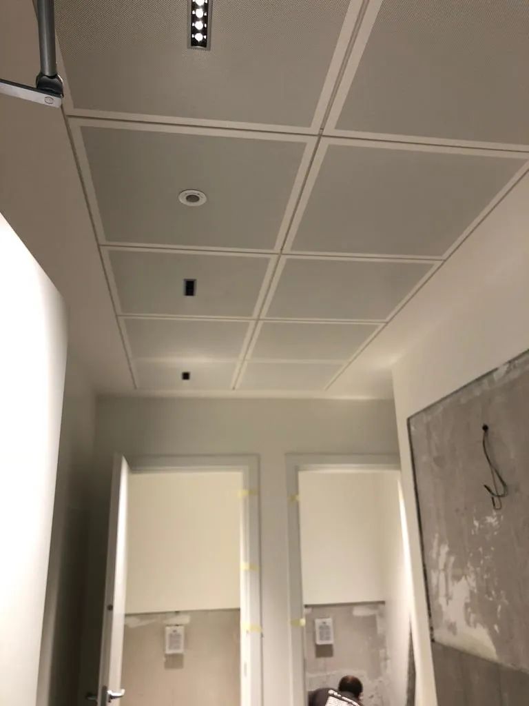Un corridoio con soffitto in maiolica e due porte.
