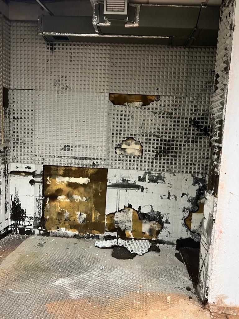 Una stanza con molti danni alle pareti e al soffitto.