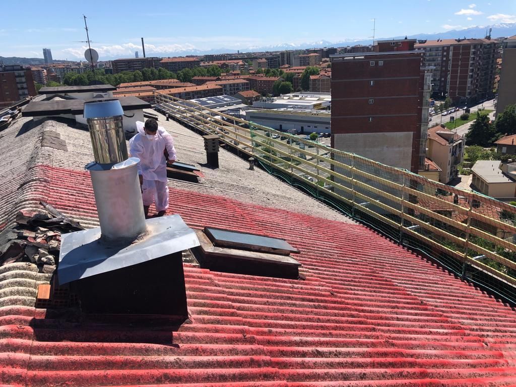 Un uomo è in piedi sopra un tetto di tegole rosse.