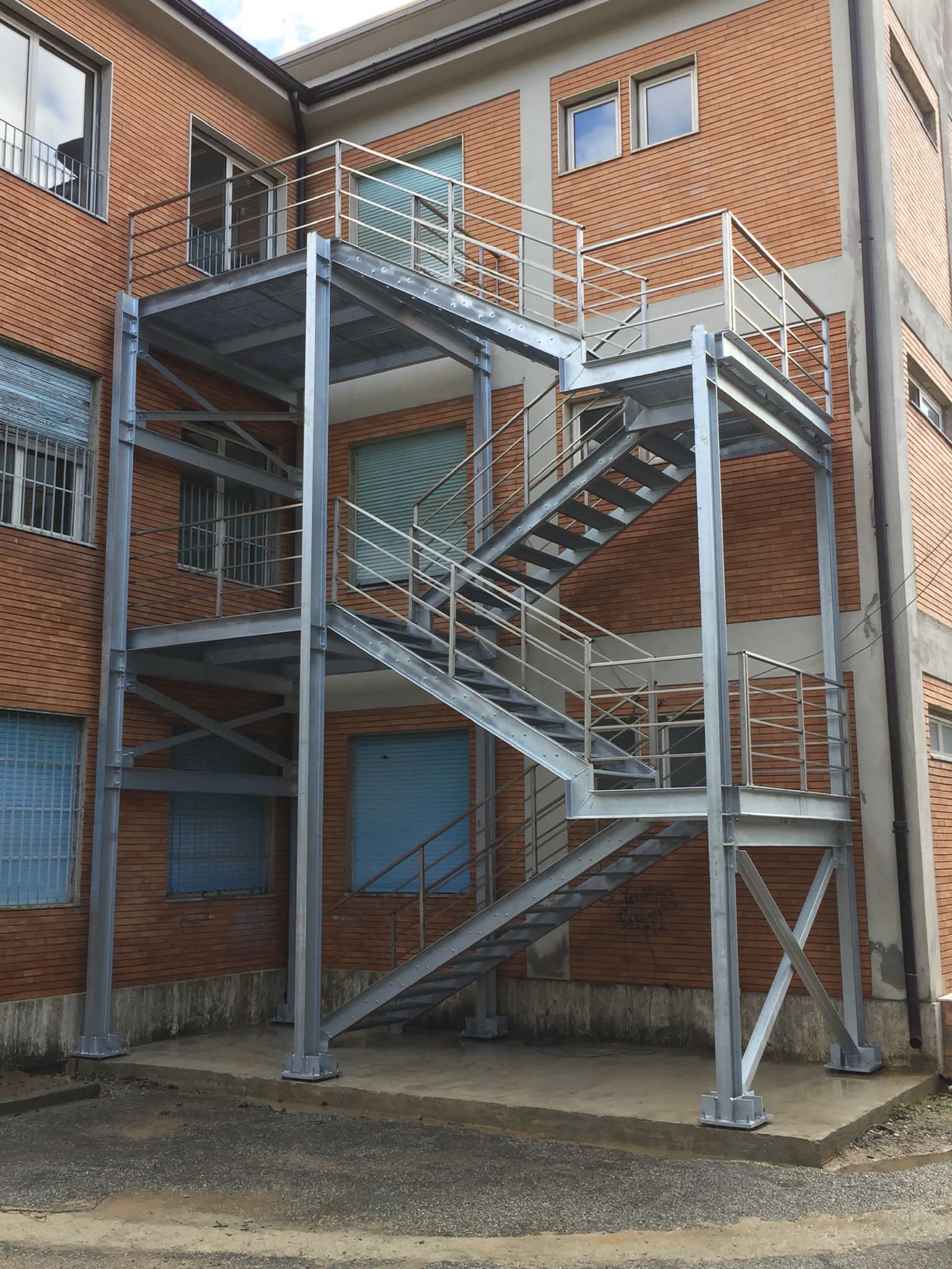 Scale antincendio esterne in metallo fissate a un edificio in mattoni.