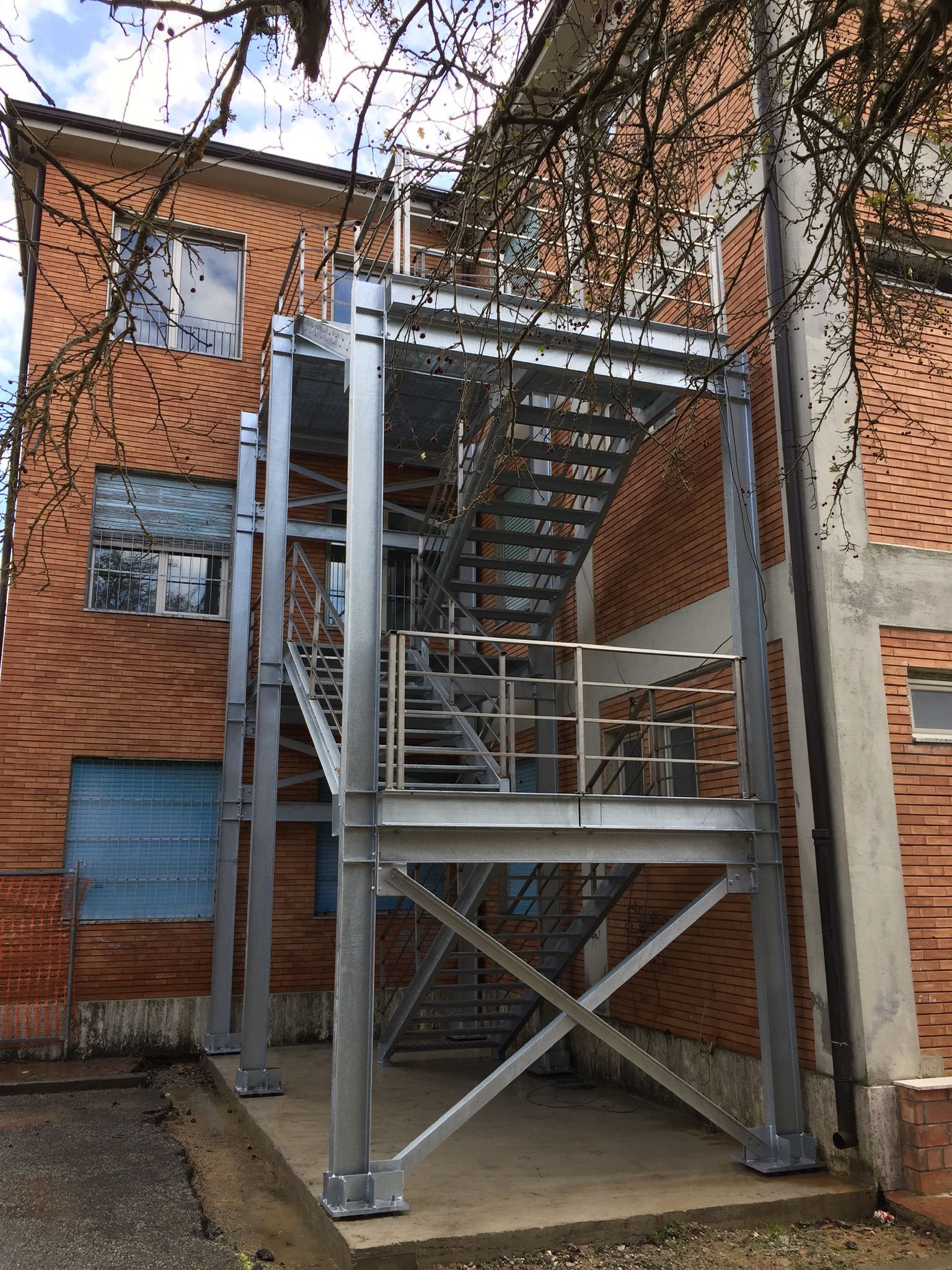 Scala esterna in metallo fissata a un edificio in mattoni.